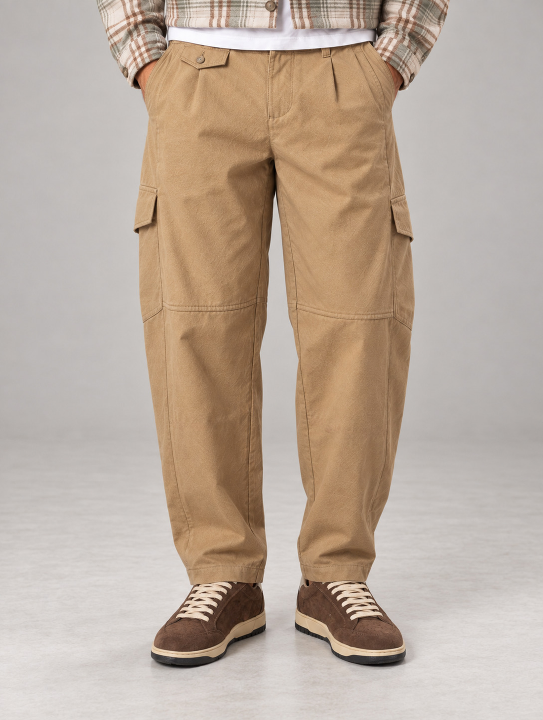 Beige cargo pants with front welt pockets on a white background